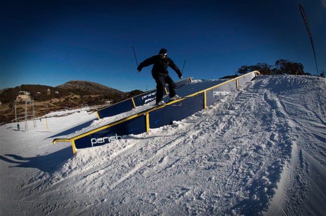 Boen Ferguson enjoying the PlayStation terrain park at Perisher - beyond the snowmaking areas the hills are very green. Image: Ben Hansen