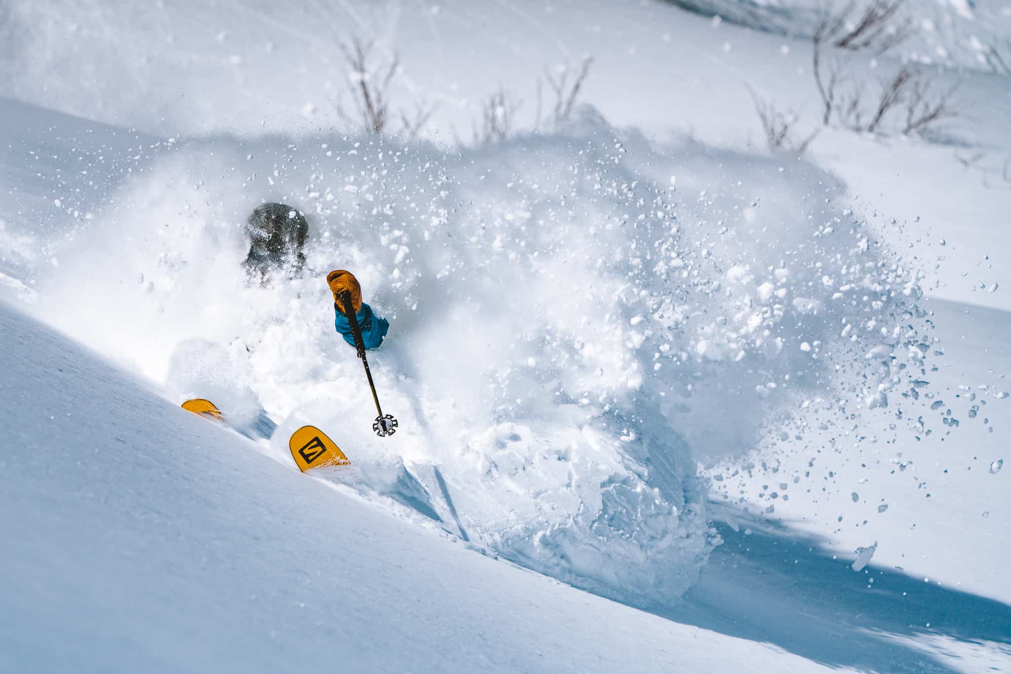 A skier enjoying a bluebird powder day in Tsugaike