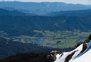 This photo captures th essence of spring skiing in Australia as Drew skis Bogong's West Peak with the township of Mt Beauty thousands of feet below